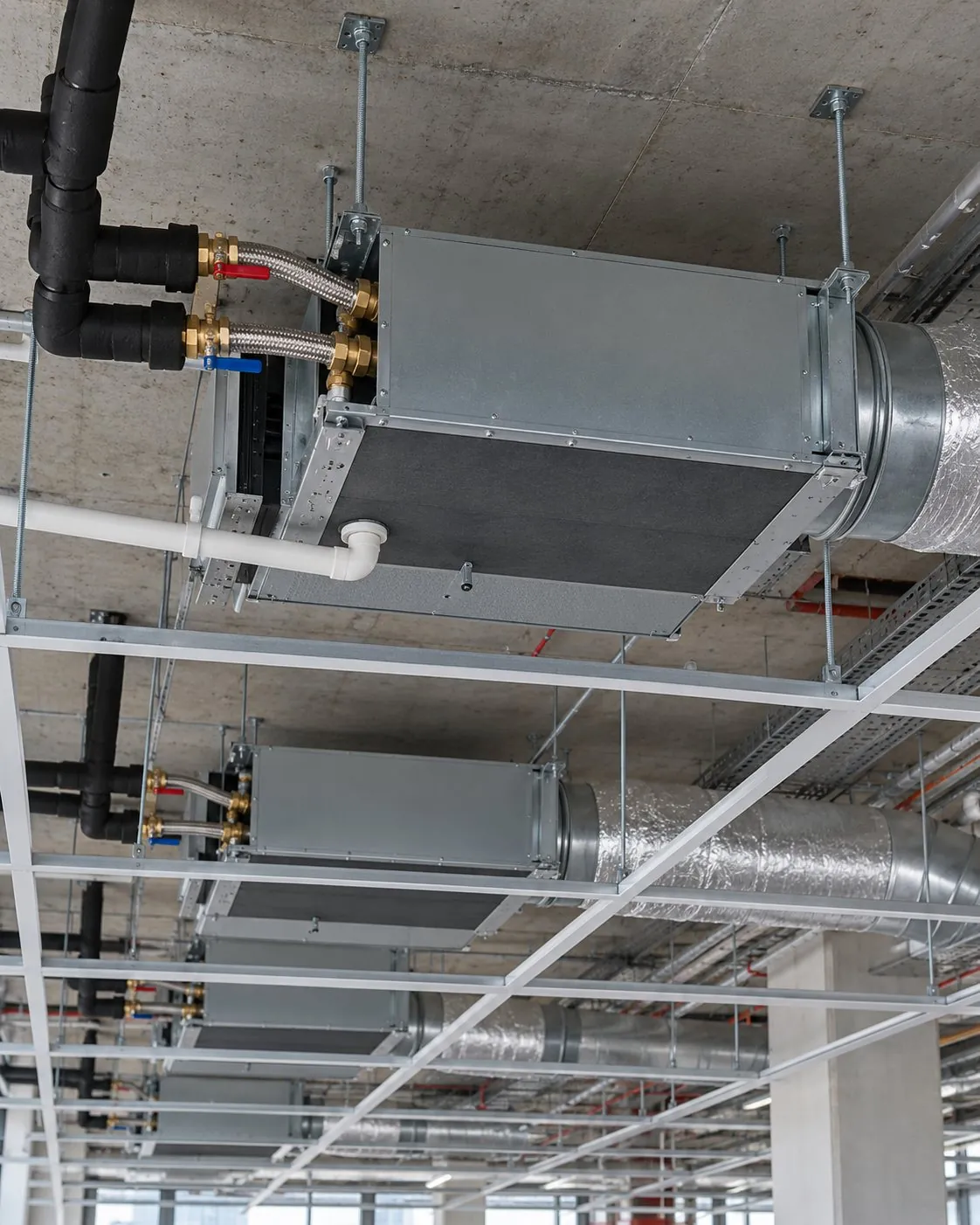 Fan coil units and pipework in an office ceiling void